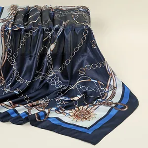 Vue rapprochée d'un foulard en satin bleu marine avec imprimé chaîne dorée élégant