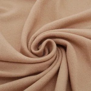 Gros plan d'une écharpe douce en imitation cachemire beige montrant la texture