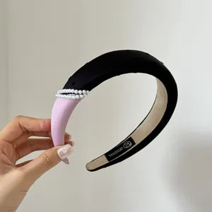 Elegant purple and black padded headband featuring pearl details and original label
