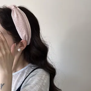 Primo piano di un cerchietto rosa a pois indossato per un look elegante e voluminoso.