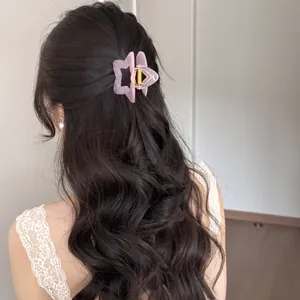 Pinza para el pelo estrella de acrílico rosa mate para peinados elegantes en melenas largas.