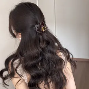 Detalle de una pinza de pelo con forma de estrella marrón en peinado ondulado