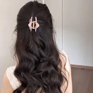 Vista trasera de pinza para el pelo rosa para un elegante peinado ondulado de medio