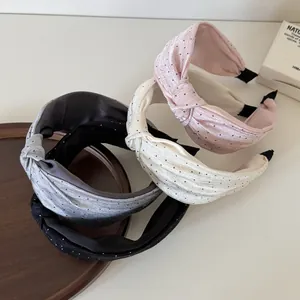 Dettaglio dei cerchietti con nodo a pois in rosa, bianco, grigio e nero di alta qualità.