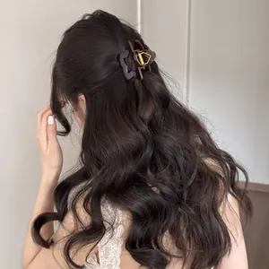 Primer plano de una pinza para el pelo con forma de estrella marrón en pelo ondulado