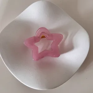 Detalle de una pinza para el pelo con forma de estrella rosa en un plato blanco