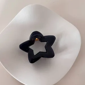 Detalle de una pinza para el pelo minimalista con forma de estrella azul en un plato blanco