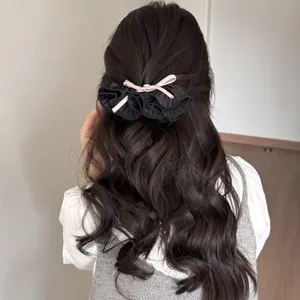 Vue arrière d'une pince à cheveux en dentelle plissée avec nœud rose et strass