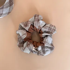 Close-up of brown plaid patchwork scrunchie with soft fabric texture