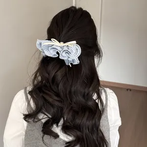Barrette à cheveux à volants bleu clair avec nœud crème et strass sur cheveux bouclés