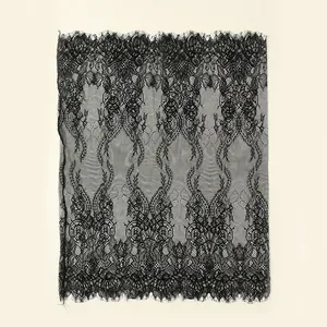 Detailed macro view of intricate black lace fabric with floral patterns and eyelash trim