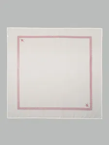 Flat lay detail of white cotton square scarf featuring elegant red ethnic print border pattern