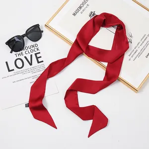 Gros plan d'une écharpe étroite en soie de mûrier rouge premium avec des accessoires
