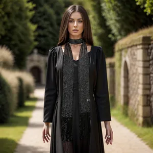 Detailed view of a black metallic silk scarf with fringe on a long sleeve dress