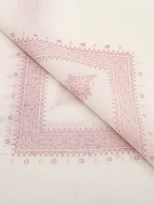 Macro detail showing the intricate pink ethnic print on a lightweight cream fabric headscarf