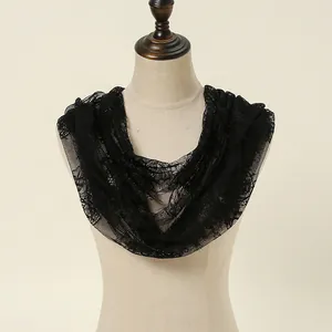 Close-up detail of a soft black lace infinity scarf with elegant floral patterns on a mannequin.