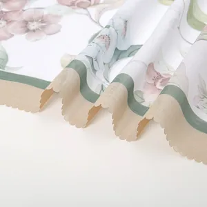 Macro view of the laser-cut scalloped edge and elegant floral print on white fabric