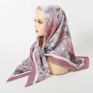 Detailed view of the laser-cut edge and floral print on a light pink chiffon hijab
