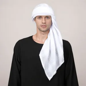 Detail of white jacquard checkered headscarf worn by male model on neutral background