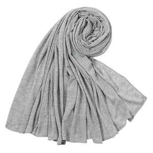Primo piano di un foulard grigio in cotone mercerizzato che mostra il drappeggio del tessuto.