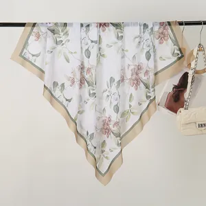 Close-up detail of a floral printed square scarf featuring delicate laser-cut edges