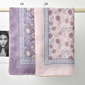 Detail view of high-quality floral print polyester square scarves in lilac and pink.