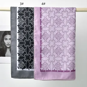 Close-up of elegant polyester square scarves with intricate floral patterns in grey and pink