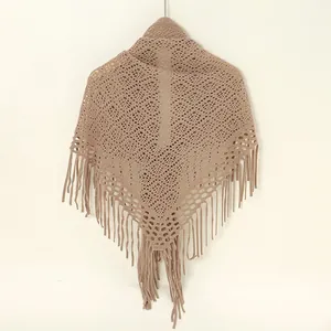 Detailansicht eines beigen Strickschals mit Lochmuster und langen Fransenquasten