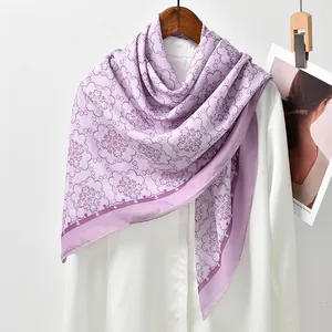Detail of light purple printed square scarf with elegant floral pattern draped on a hanger