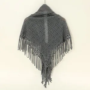 Nahaufnahme eines grauen gestrickten Dreieckstuchs mit elegantem Hohlmuster und Fransen.