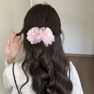 Elegante pinza para el cabello de malla rosa plisada en cabello largo oscuro ondulado