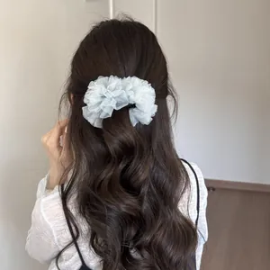 Pinza para el pelo tipo banana de malla plisada blanca en pelo largo castaño ondulado detrás