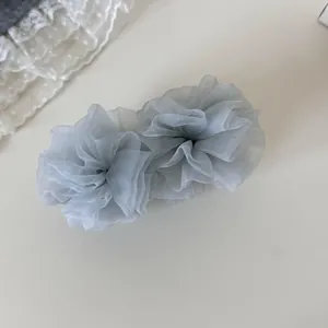 Primer plano de una pinza para el pelo de malla gris con elegante textura de organza