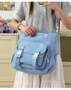 Bolsa escolar azul cielo de gran capacidad mostrada en una modelo, con hebillas blancas