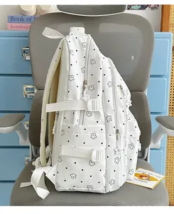 Side view of white student school backpack with cute black star and dot pattern detail