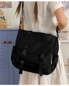 Vista detallada de un bolso bandolera negro de gran capacidad llevado por una joven estudiante