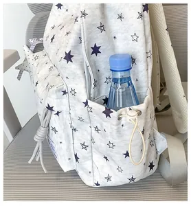 Close-up of side pocket on white star print backpack with blue water bottle