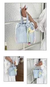 Detalle de un elegante bolso de tela a cuadros azules y blancos con cordón y dije de luna