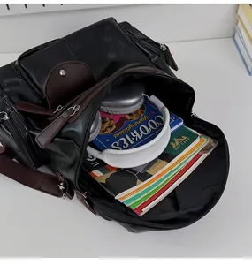 Close-up of black leather motorcycle backpack interior showing large capacity with items