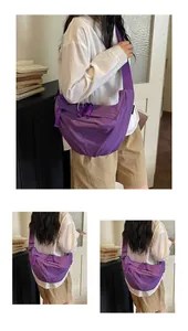 Dettaglio borsa a tracolla a mezzaluna in nylon viola da donna con ampia tracolla regolabile