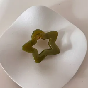 Primer plano de una pinza para el pelo minimalista verde oliva con forma de estrella