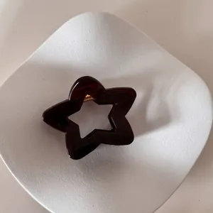 Detalle de una pinza para el pelo con forma de estrella ámbar en plato blanco