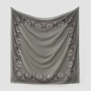 Vue détaillée de haute qualité d'une écharpe en mousseline grise à bordure paisley