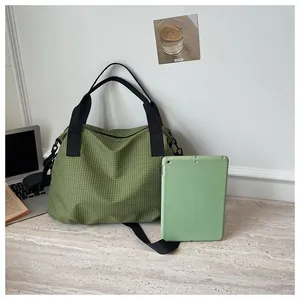 Large green checkered nylon tote bag displayed with a tablet to show its capacity