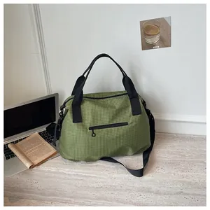 Green checkered nylon tote bag on a desk with a laptop and book, showing daily use