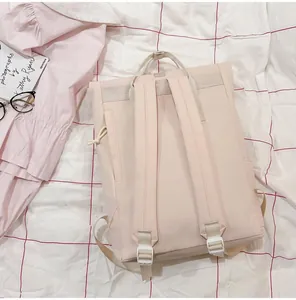 Detailed rear view of a minimalist lightweight travel backpack in soft beige pink canvas