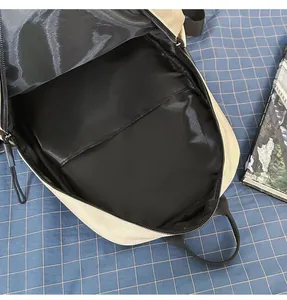 Interior view of minimalist beige backpack showing black lining and main compartment