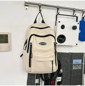 Minimalist beige PU leather backpack with black zippers hanging in a modern lifestyle room