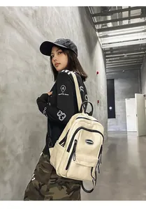 Minimalist cream leather backpack for students in a casual street style look.