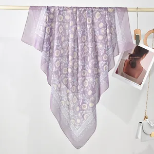 Close-up view of a purple polyester square scarf with rose print and geometric borders